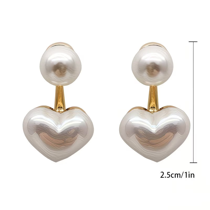 Double pearl heart earrings photographed from a side angle