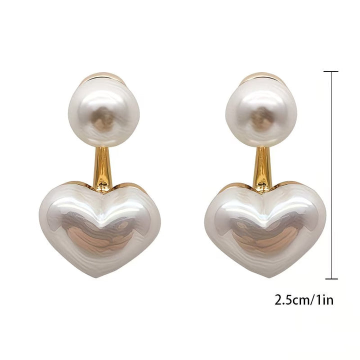 Double pearl heart earrings photographed from a side angle