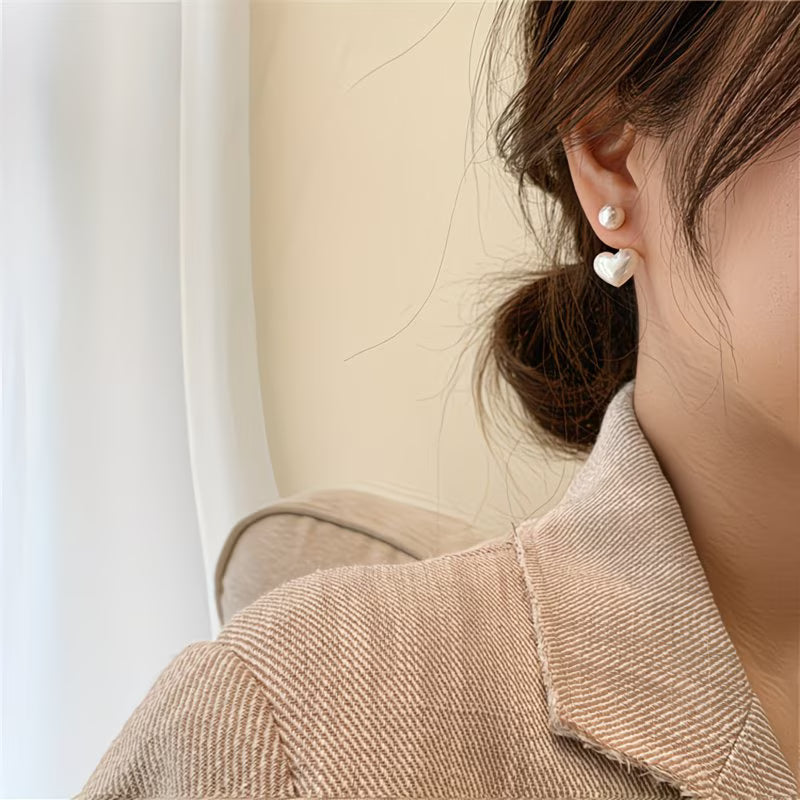 Close-up of the heart-shaped charm on the pearl earrings