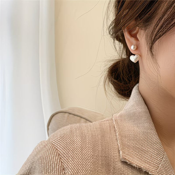 Close-up of the heart-shaped charm on the pearl earrings