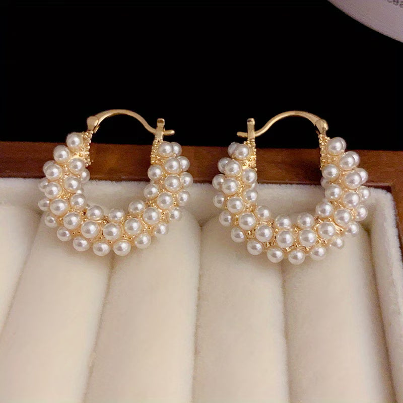 Layered pearl hoop earrings on a plain white background