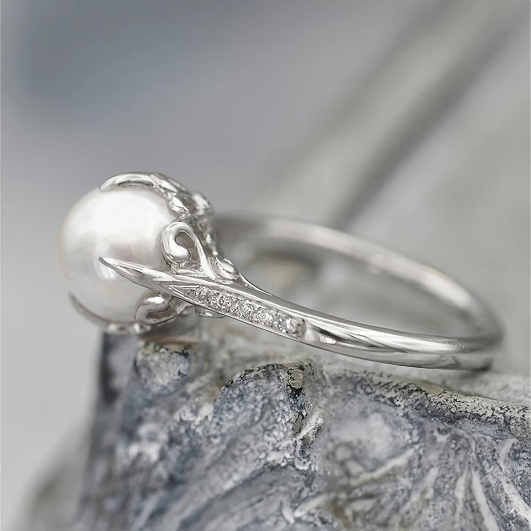 Pearl and crystal ring shown worn on a hand