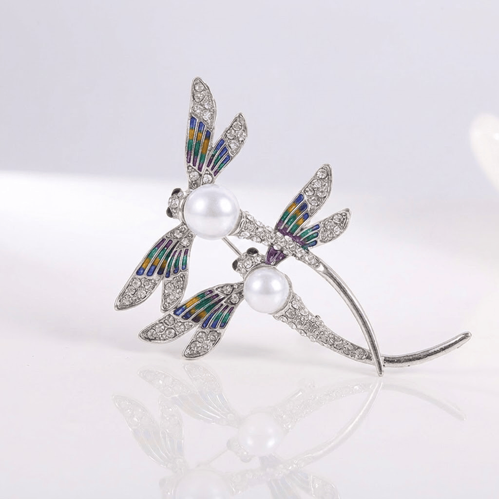 Vintage dragonfly pearl brooch shown on a plain background