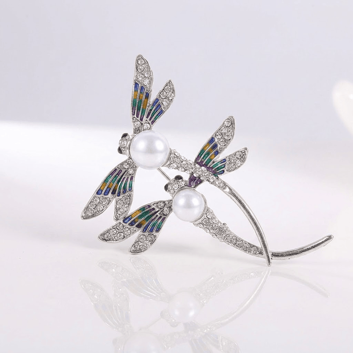 Vintage dragonfly pearl brooch shown on a plain background