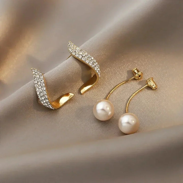 Crystal plume pearl earrings worn on a model's ear