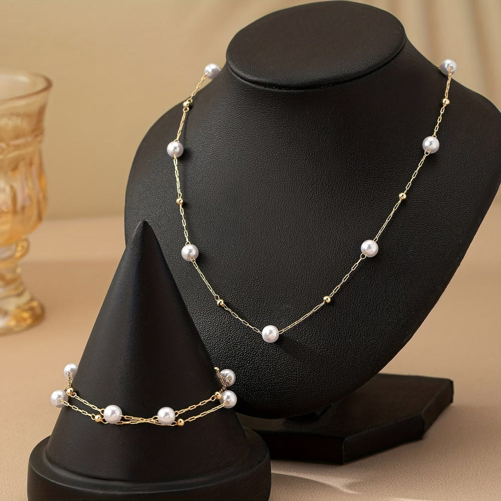 Close-up of small pearls scattered along the fine gold-tone chain