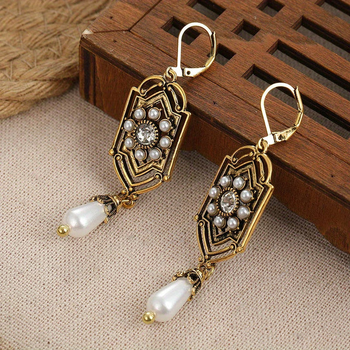 Vintage golden inlaid pearl earrings photographed from an angle