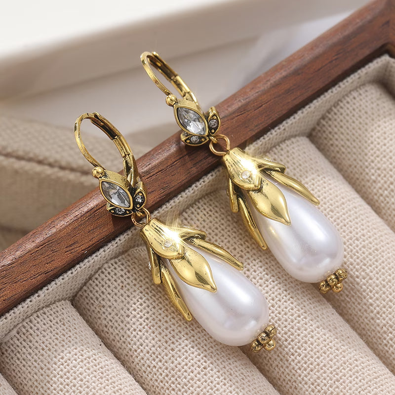 Vintage botanical pearl earrings displayed on a flat surface