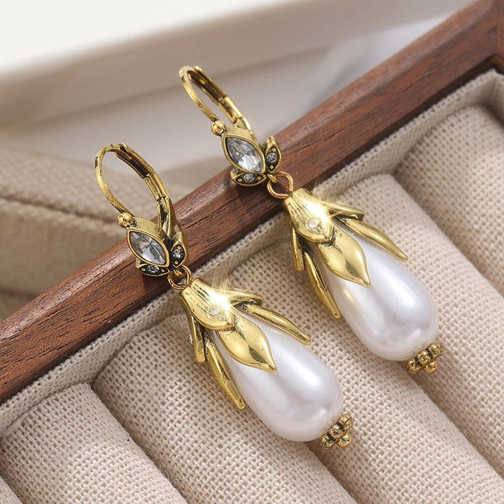 Vintage botanical pearl earrings displayed on a flat surface