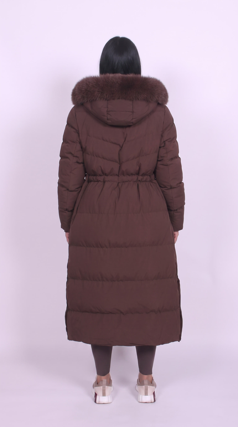 Back view of brown maxi puffer coat with fur trimmed hood and elasticated waist