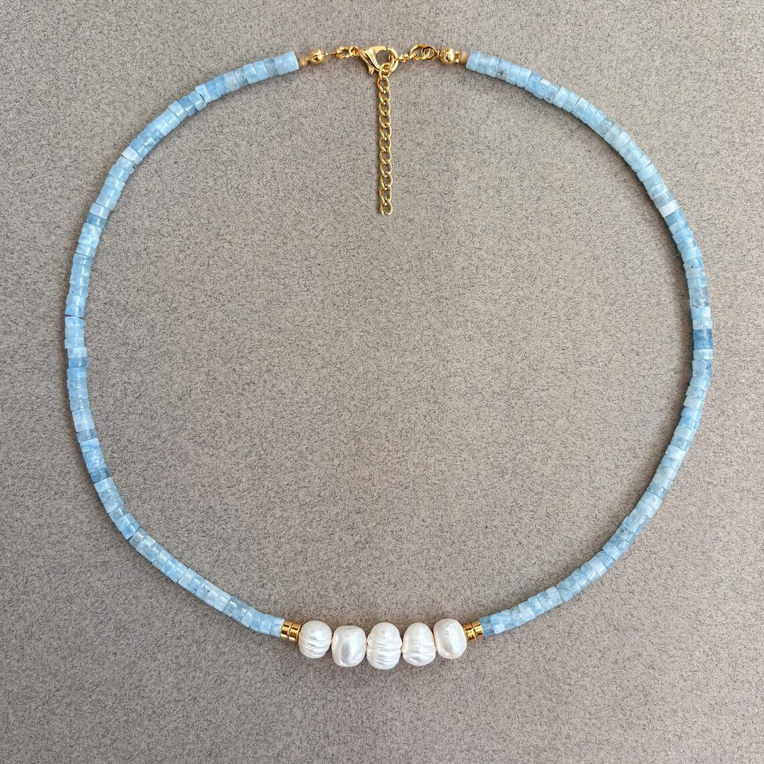 Necklace styled flat beside matching stud earrings