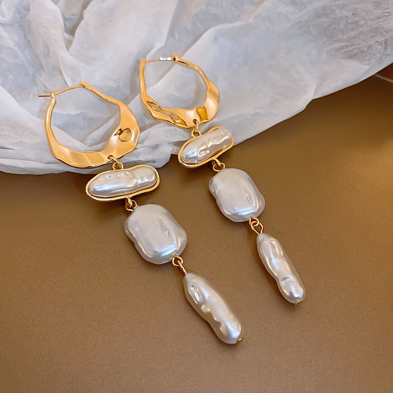 Baroque pearl hoops worn in the ear to show the fit