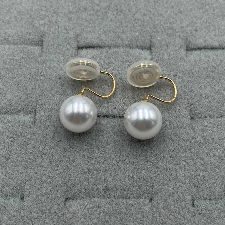 Pearl clip earrings styled flat beside a matching necklace