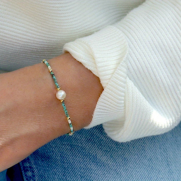 Turquoise pearl bracelet worn stacked on a model's wrist