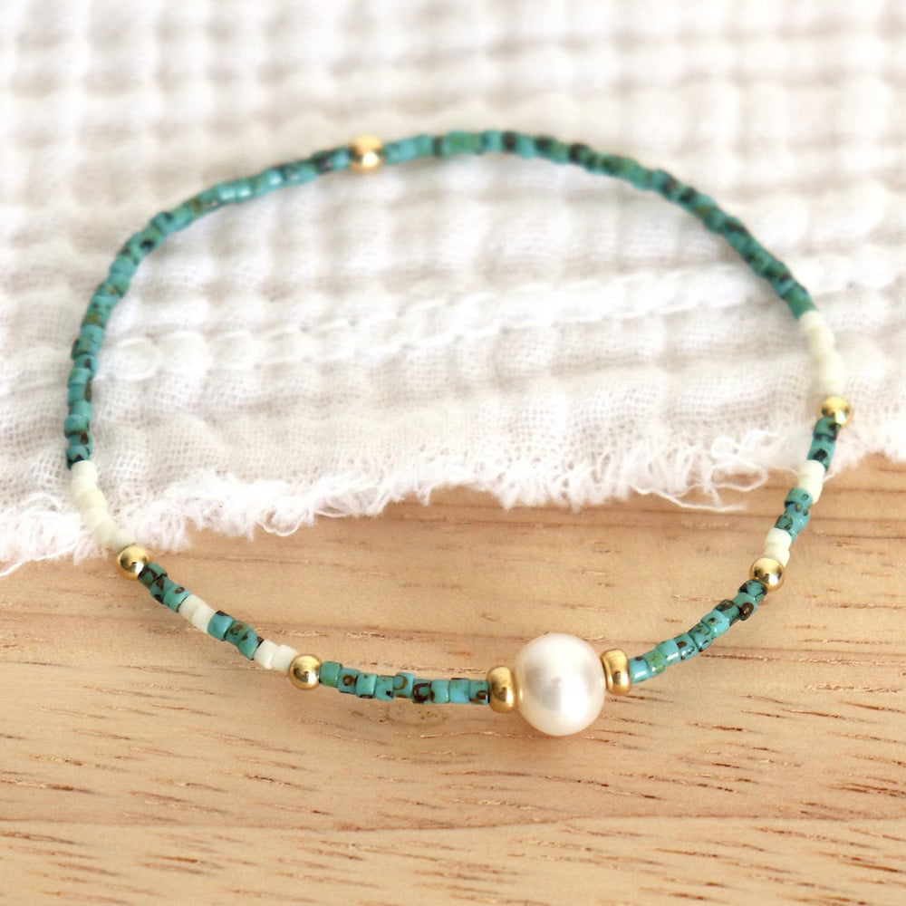 Close-up of turquoise beads alternating with small ivory pearls
