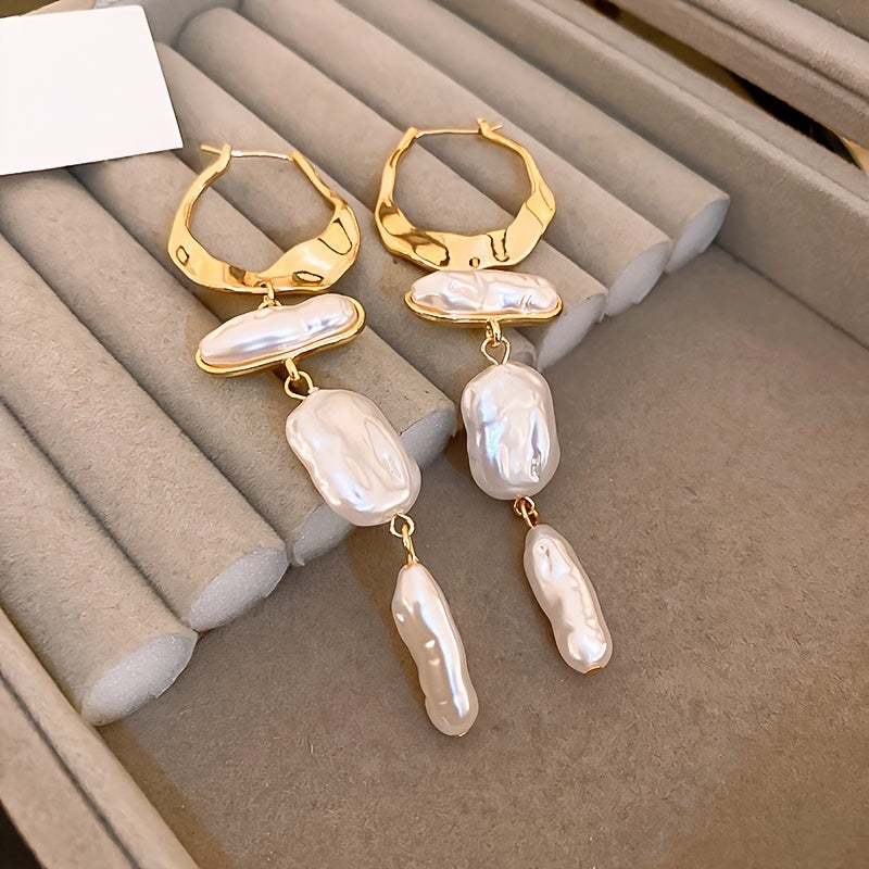 Elegant baroque pearl hoop earrings on a white background