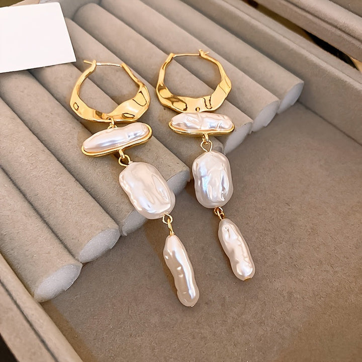 Elegant baroque pearl hoop earrings on a white background