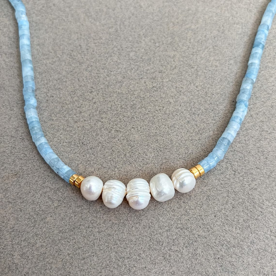 Necklace clasp shown in detail against soft fabric