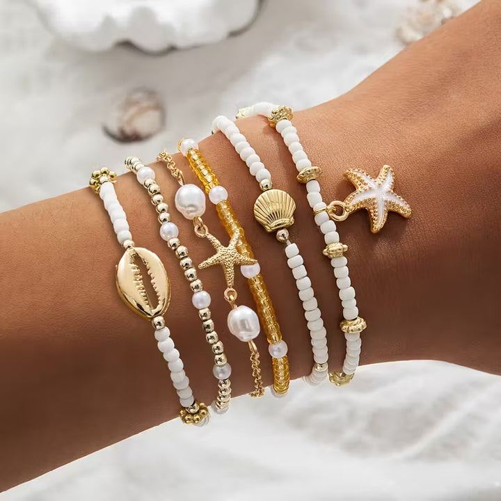 Coastal gold and pearl bracelet set of six laid out together