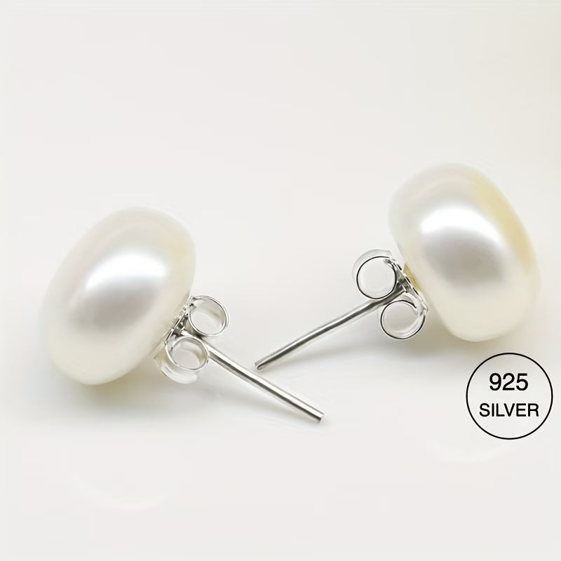 Pair of classic pearl stud earrings laid flat side by side