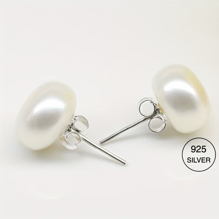Pair of classic pearl stud earrings laid flat side by side