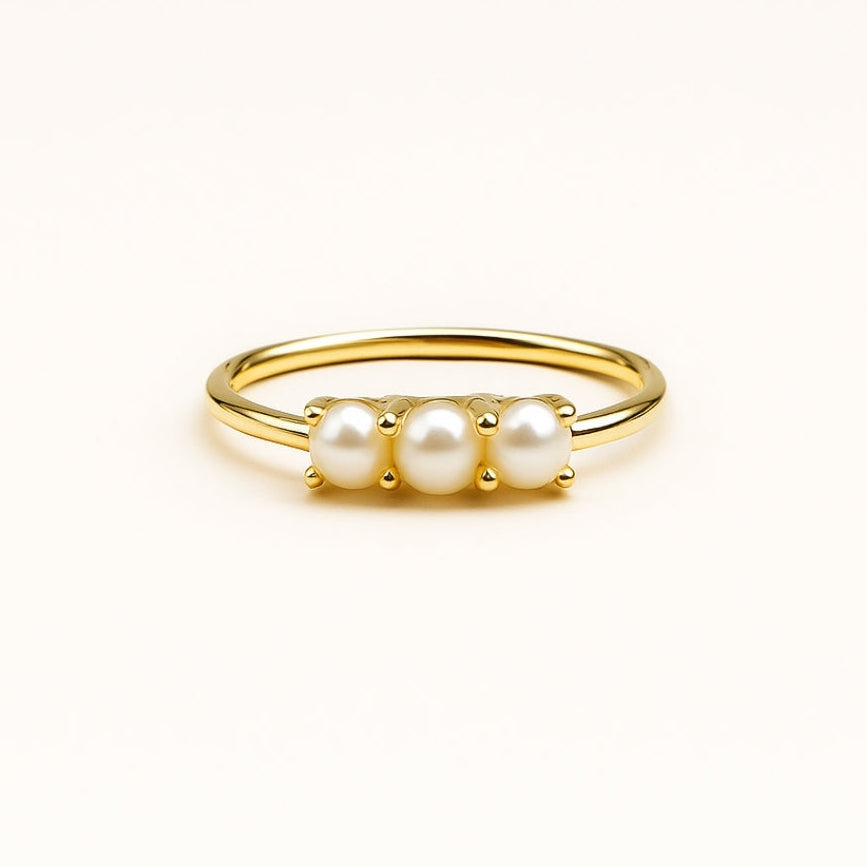 Triple pearl trail ring photographed on a clean white backdrop