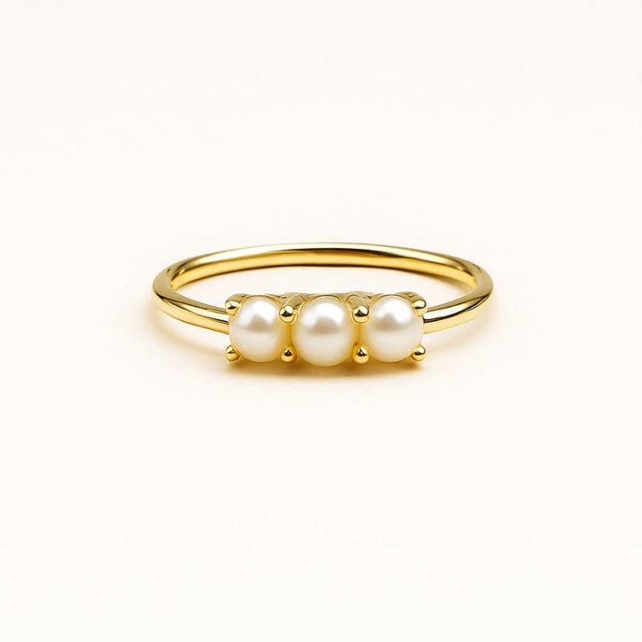 Triple pearl trail ring photographed on a clean white backdrop