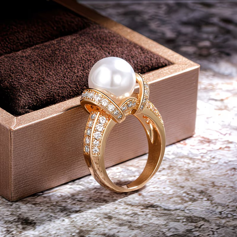 Crown pearl ring in gold-tone metal on a white background