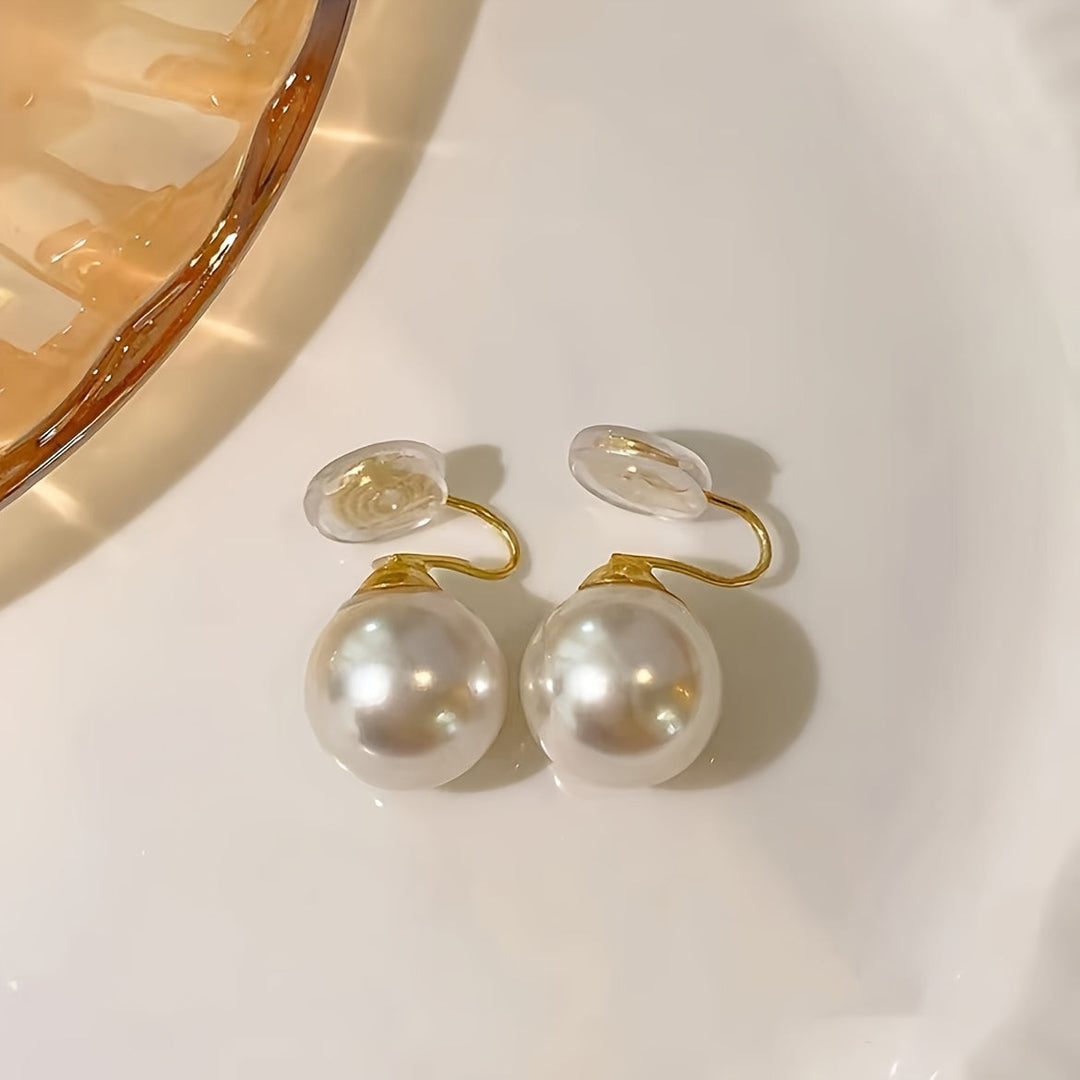 Vintage round pearl clip earrings shown on a white background