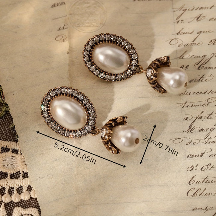Pearl frame drop earrings shown from a side angle
