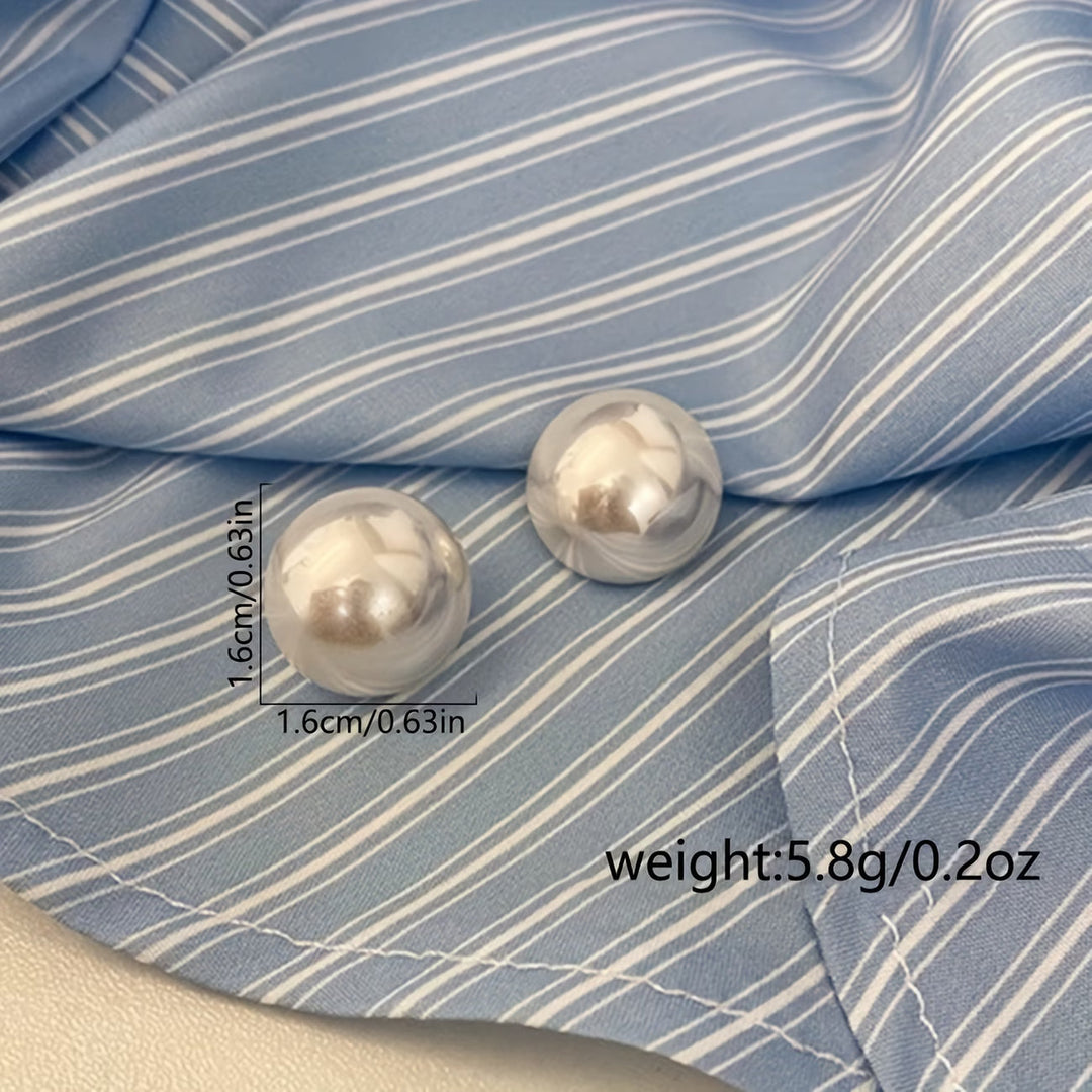 Pearl stud earrings displayed from a side angle