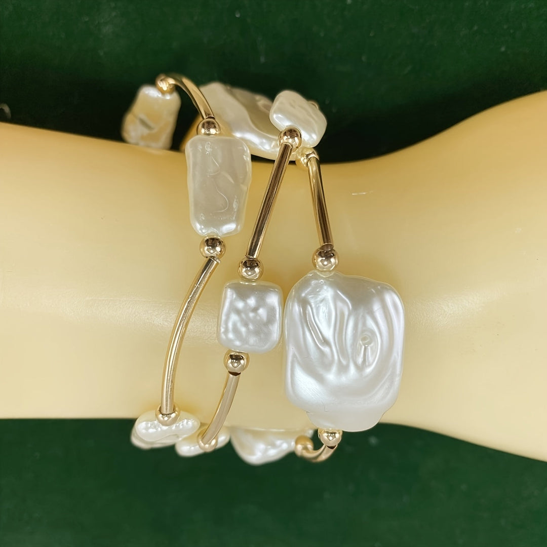 Stack of baroque pearl bracelets worn on a wrist