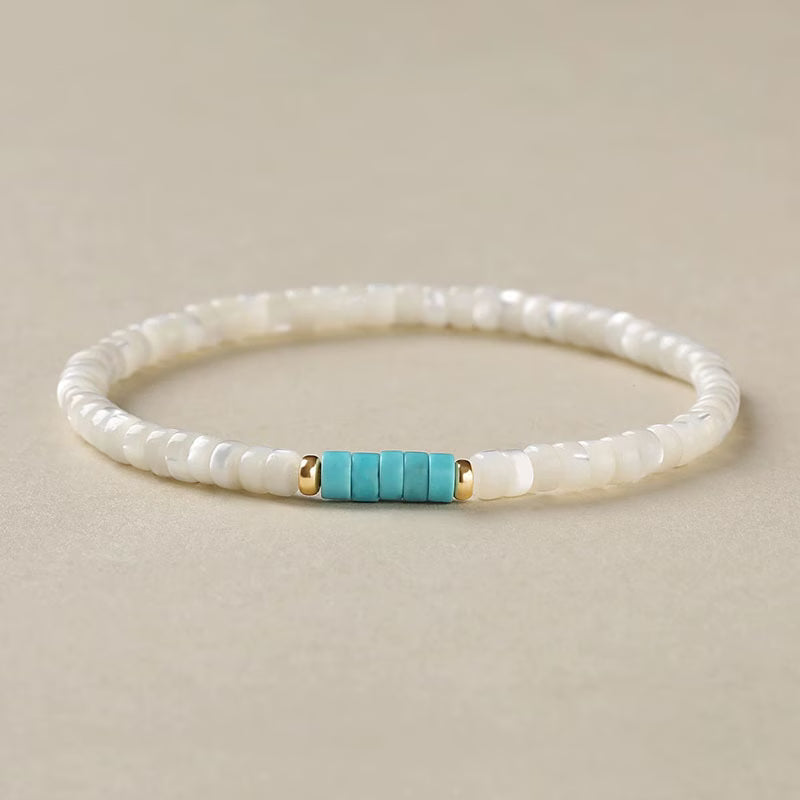 Elegant pearl and turquoise bracelet on a plain white background