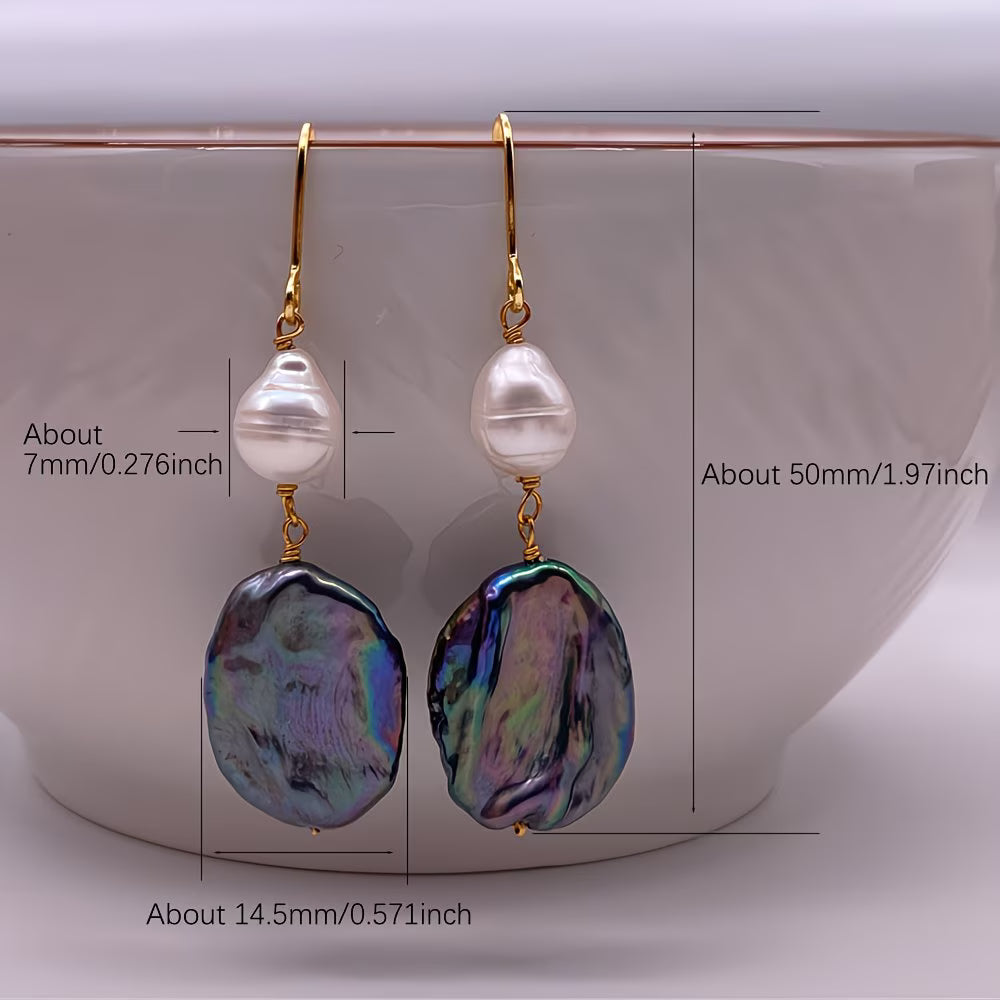Pearl drop earrings worn in the ear to show the sheen