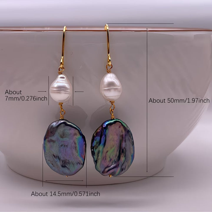 Pearl drop earrings worn in the ear to show the sheen