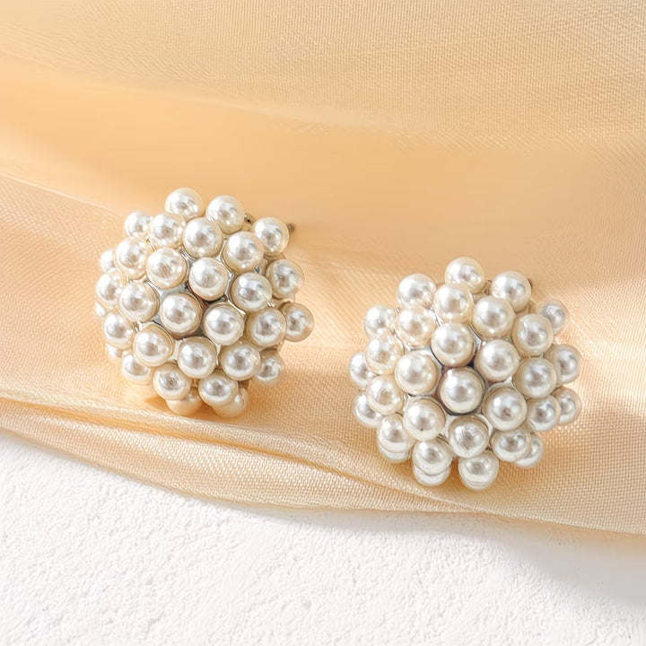 Pearl stud earrings worn in the ear to show the fit