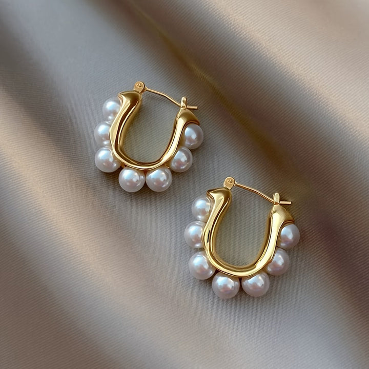 Clustered pearl hoop earrings shown against a plain background