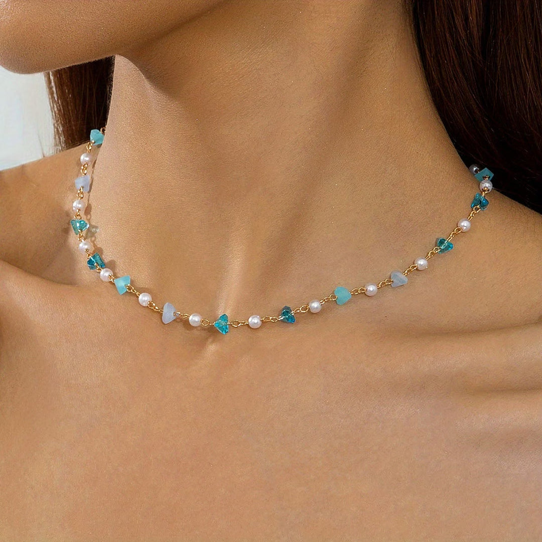 Pearl and turquoise beaded bracelet coiled on a white background