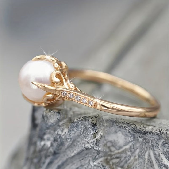 Pearl and crystal ring photographed on a plain background