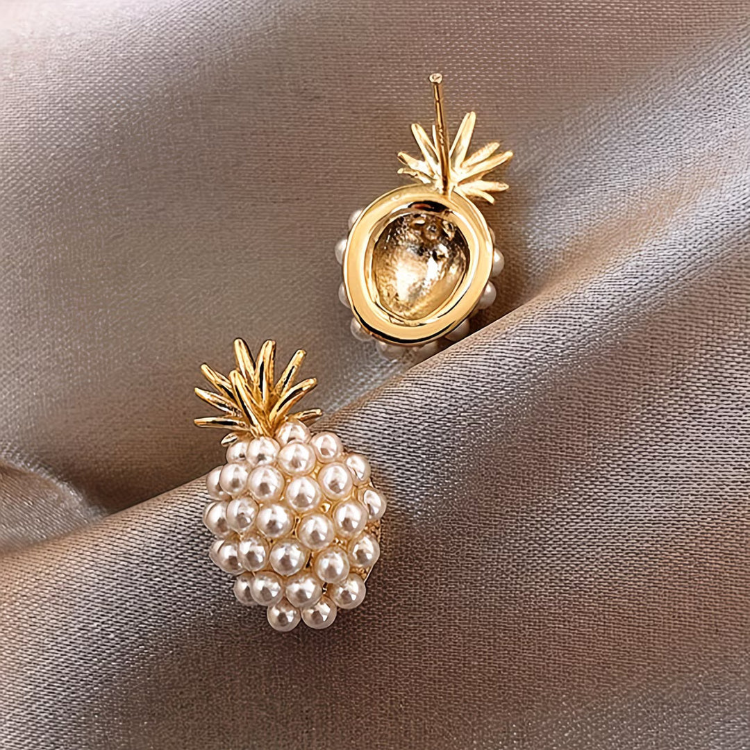 Close-up of the gold-tone pineapple charm and pearl detailing