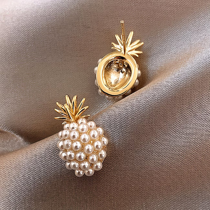 Close-up of the gold-tone pineapple charm and pearl detailing