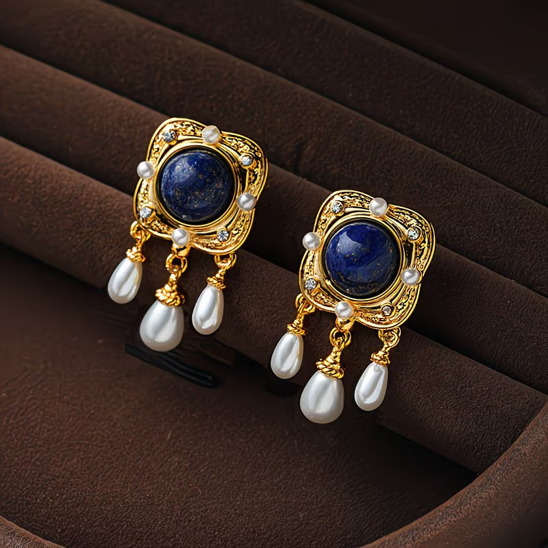 Royal blue pearl chandelier earrings displayed on a flat surface