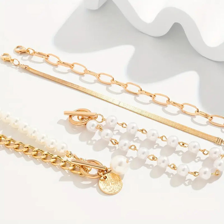 Close-up of pearls layered against fine gold-tone chain links