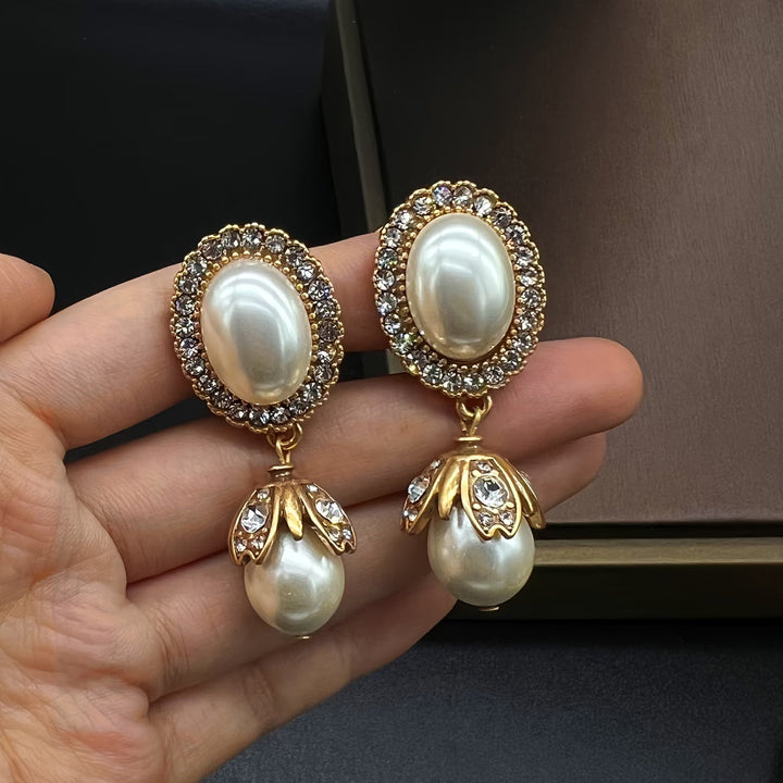 Vintage pearl frame drop earrings on a white background