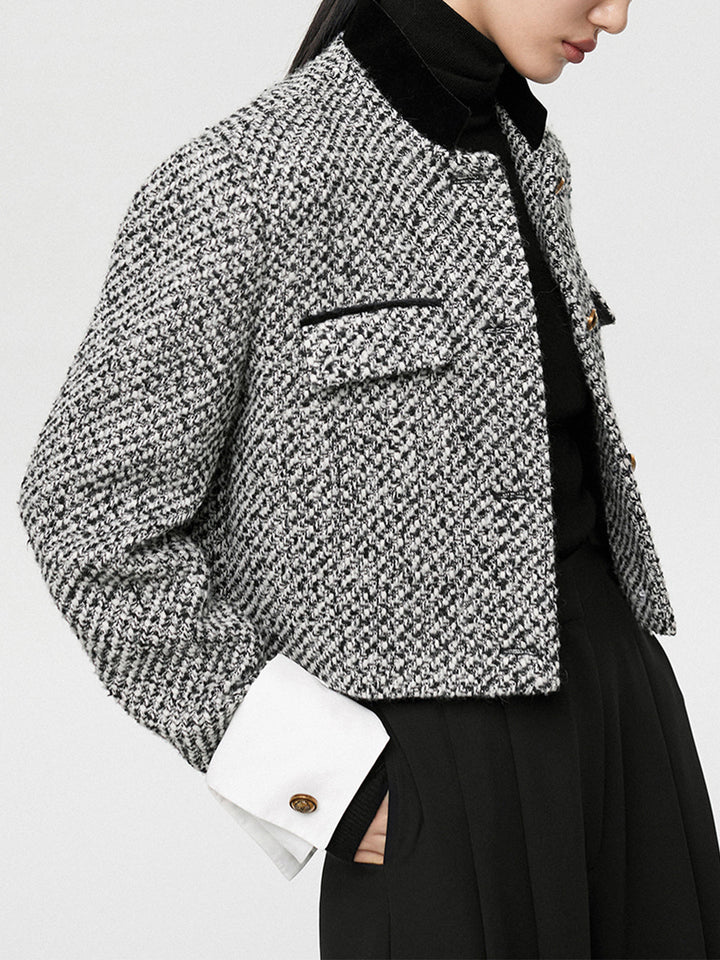 Close-up of tweed boucle weave, flap pockets and gold button cuff detail