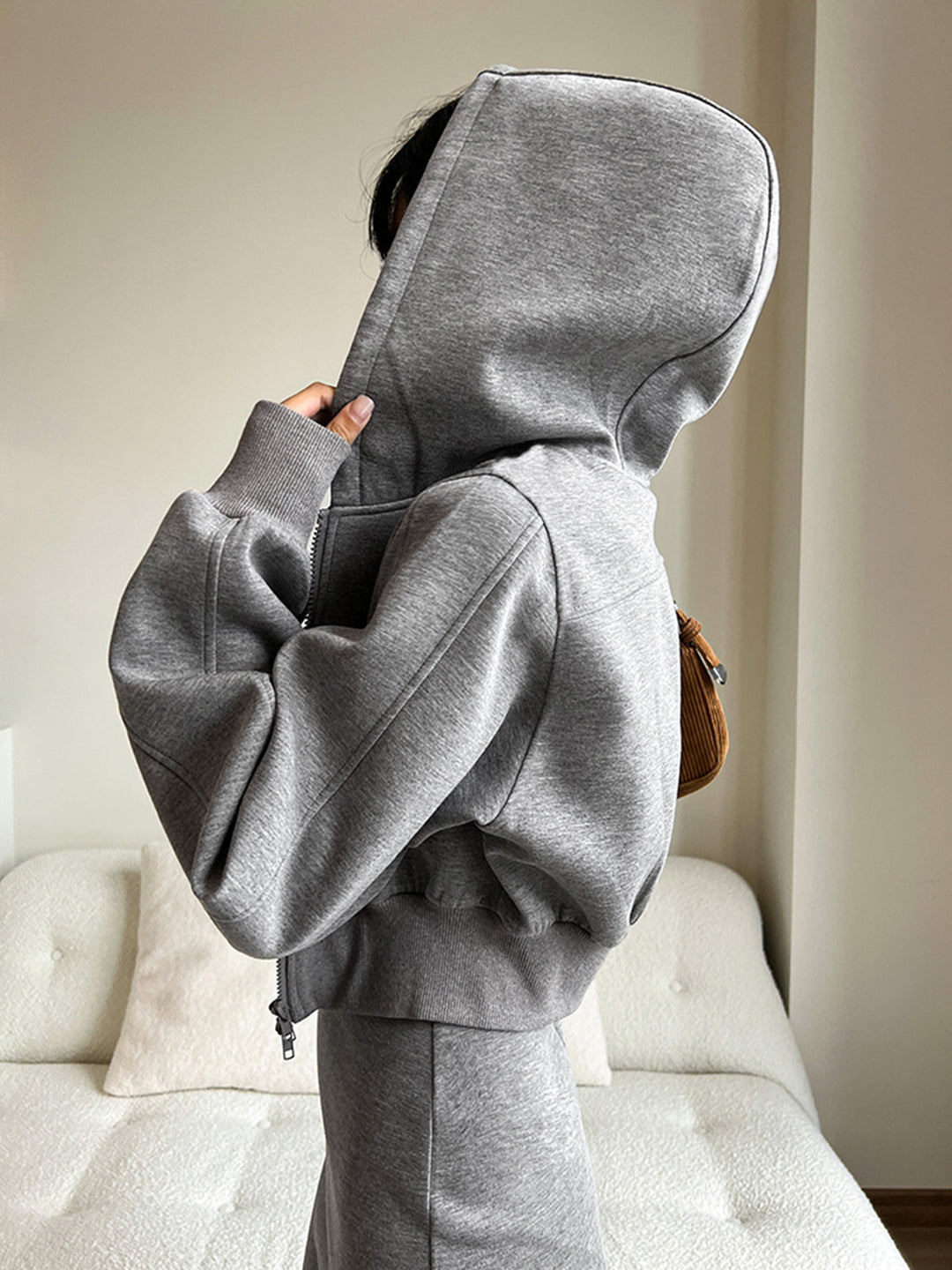 Side view of the cropped zip hoodie with the hood up and balloon sleeves