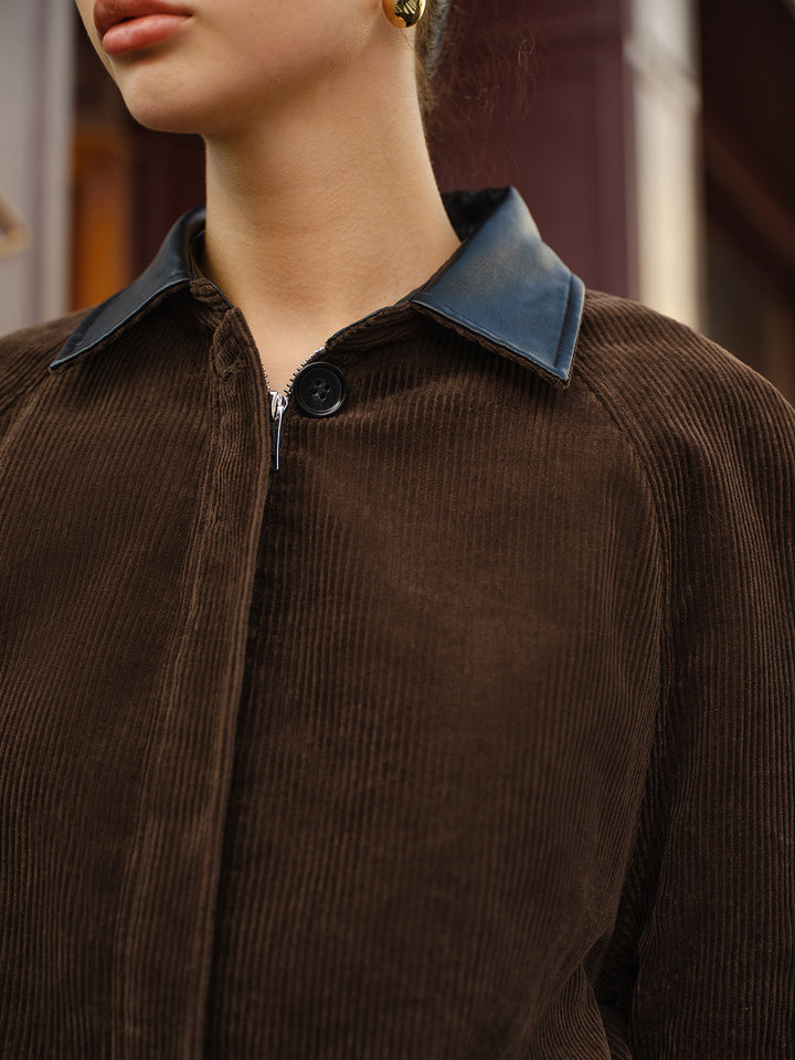 Close-up of the black leather contrast collar and zip on the brown corduroy jacket
