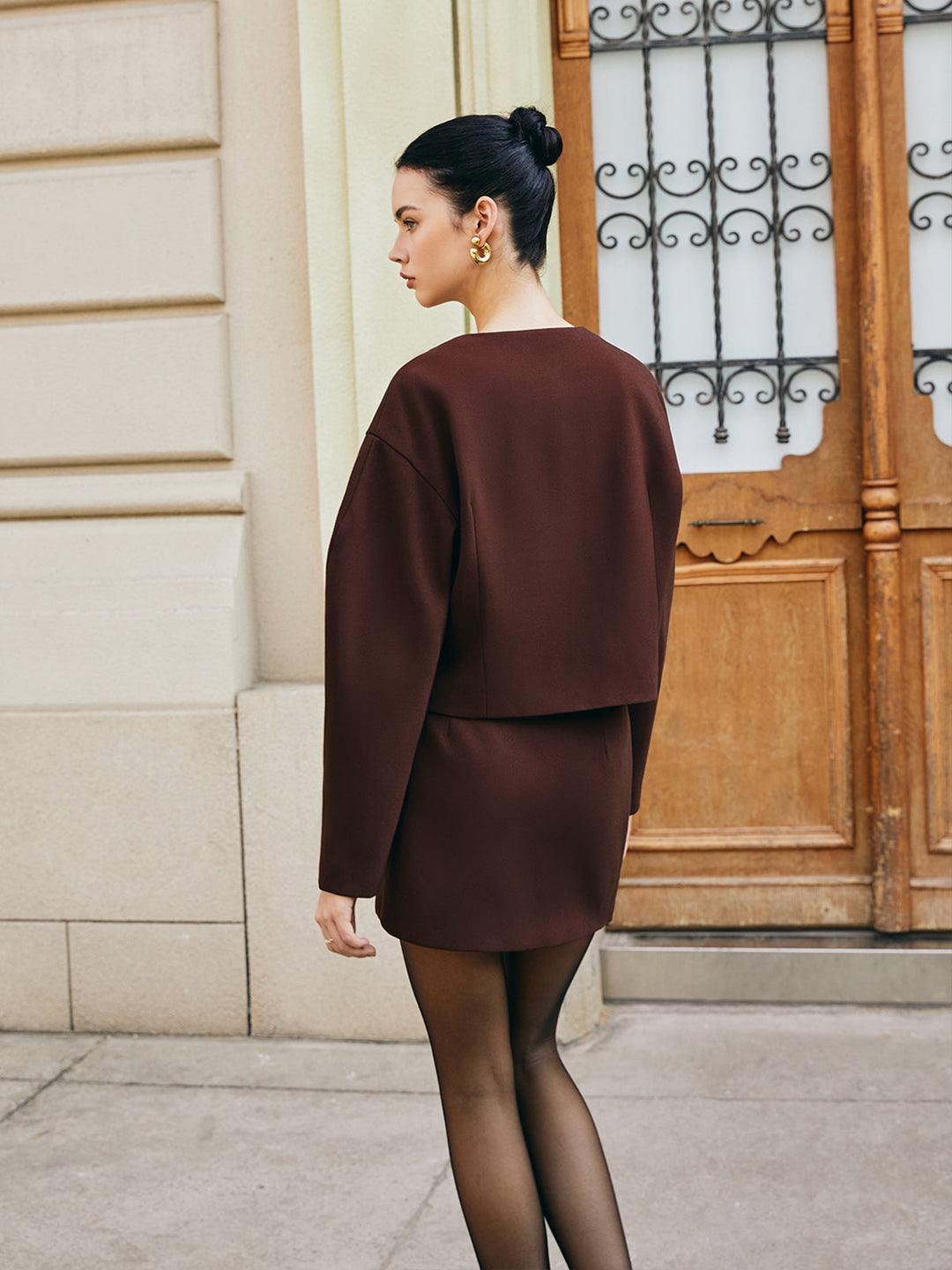 Back view of brown puff sleeve short jacket showing rounded shoulder volume