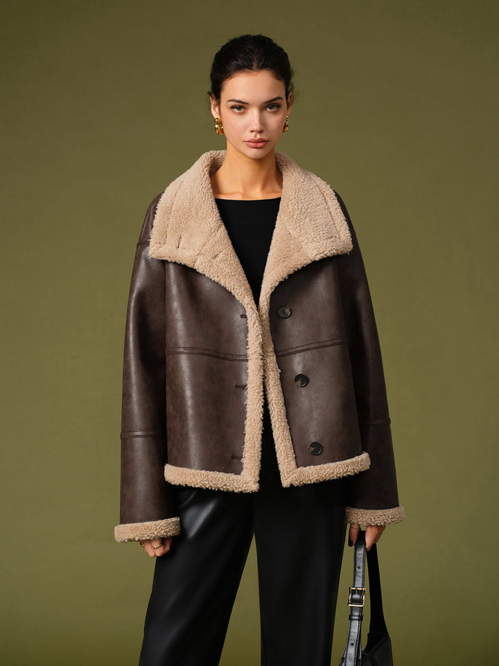 Front view of the warm brown sherpa lined jacket worn open over a black top