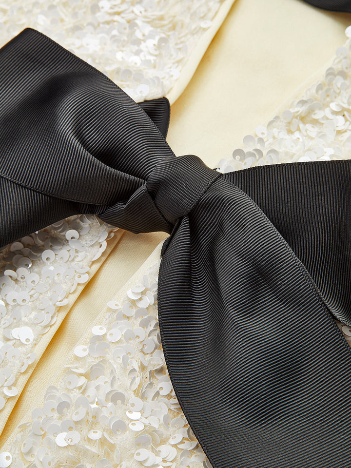 Close-up of the black satin bow against the iridescent cream sequin fabric